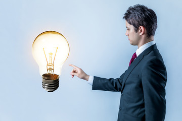 Fototapeta na wymiar businessman pointing at electric bulb, getting an good idea concept