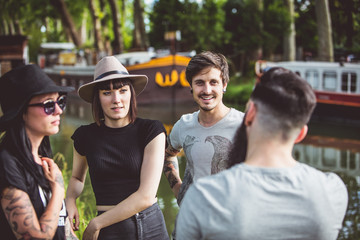 Groupe de jeunes Hipster en pleine discussion sur les berges de la Garonne, des péniches en arrière plan