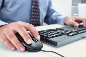 Businessman using computer with hands typing on a keyboard