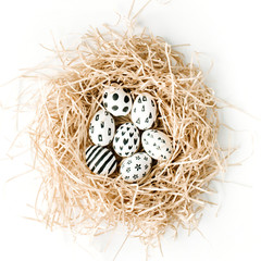 Naklejka na ściany i meble Fancy Easter eggs in nest on white background. Flat lay, top view. Traditional spring concept.