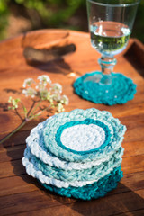 Pile of Round Knitted Woolen Coasters in Wooden Tray