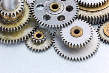 set of various old metal machinery gears on scratched background