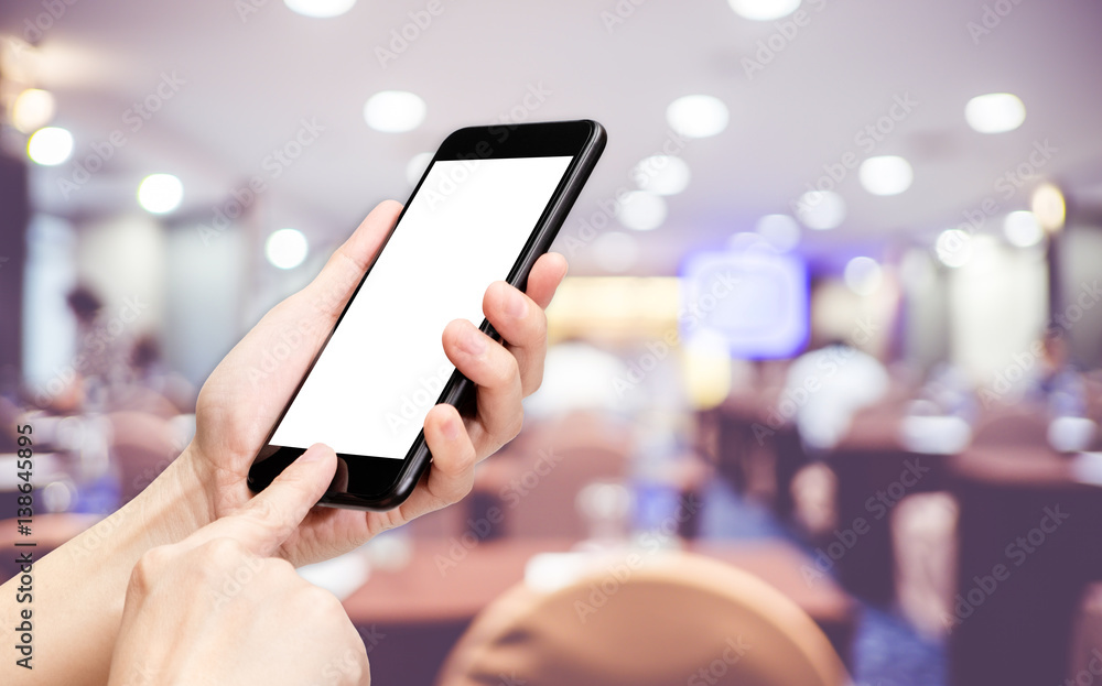 Poster Hand click mobile phone with blur seminar hall room background bokeh light,White screen mock up template for adding your design or your text