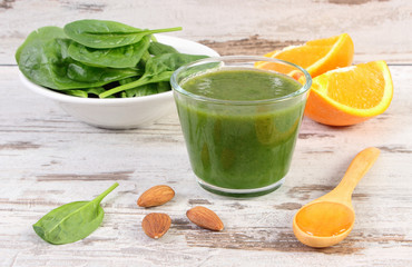 Ingredients and fresh cocktail from spinach on wooden background, healthy nutrition