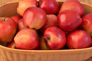 Red apples arranged in rustic bowl