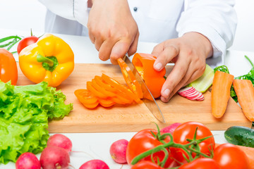 preparation of cutting vegetables for salad, close up hands of chef with knife