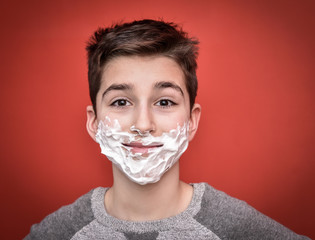 Young boy with shaving foam on his face