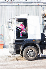 child driving a truck. A child plays in the truck driver. child turns the wheel of a large truck