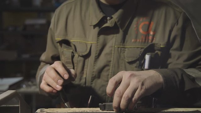 Concept of the engineering profession. A technician at work. Medium shot: Engineer working in robe holding hands in an electronic caliper and measures the width of the metal part of the future device