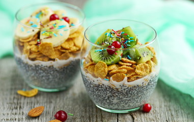 chia pudding with corn flakes and fresh fruit on a wooden vintage background 