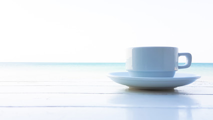 coffee cup on the wooden table with sunflare