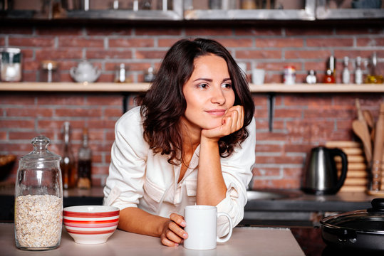 Young Happy Woman Drinking Coffee On The Kitchen