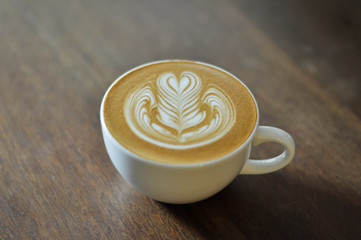 Coffee cup with latte art on the wood table