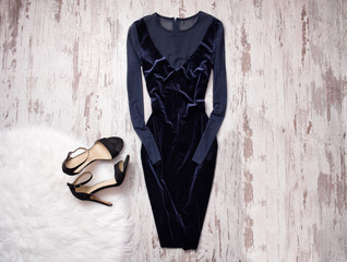Evening velvet blue dress with chiffon, black shoes Wooden background, space for text. Fashion...
