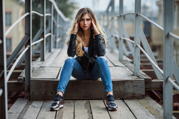 Outdoor lifestyle fashion portrait of pretty young girl, wearing in hipster swag grunge style on...