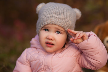 Portrait of beautiful happy child on autumn colorful leaves and grass background. Funny girl outdoors in fall park.