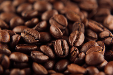 Roasted coffee beans closeup top view as background.