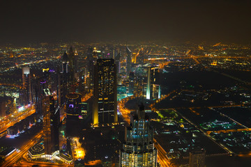 Obraz na płótnie Canvas Panoramic aerial view on downtown of Dubai with modern high skyscrapers at night. Architecture of future with bright lights and roads. Famous tourist destination