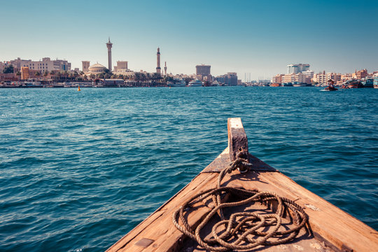 Panoramic view from traditional water taxi boats in Dubai, UAE. Creek gulf and Deira area. United Arab Emirates famous tourist destination. Creative color post processing.