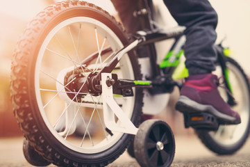 Close-up children's feet on the bicycle pedals