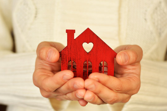 Warm and cozy miniature house in female hands. Care and love.