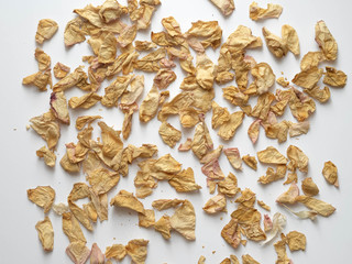 Dried rose petals on white background. Flat lay. Copy space.