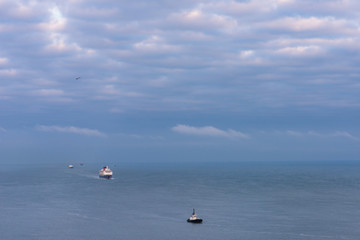 Large ocean cruise ship following small boat in ocean