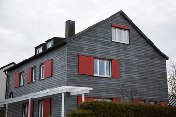 Holzhaus mit roten Rolläden