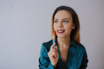 woman applying foundation blusher with makeup brush
