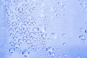 Abstract water drops on a white background with blue light