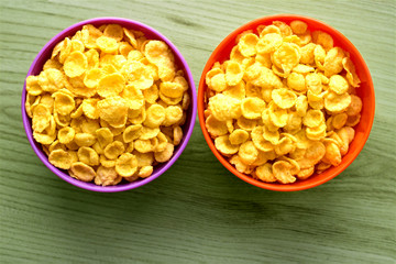cornflakes in two bowls on the grain background