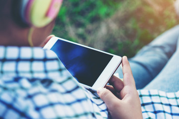 free happy cute girl enjoying. A beautiful kids hipster girl listening to music on headphones in the park.