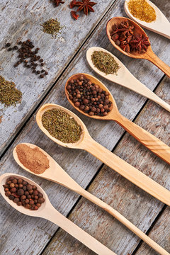 Aromatic and colorful spices in wooden spoons.