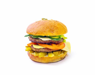 a huge hamburger with tomato and cucumber on white background