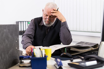 Mann am Schreibtisch mit Stress und Burnout