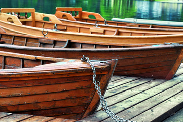Old wooden rowing boats on a wooden pier .Sport boats for recreation on lake .Blurred background 