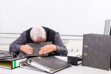 Mann am Schreibtisch mit Stress und Burnout