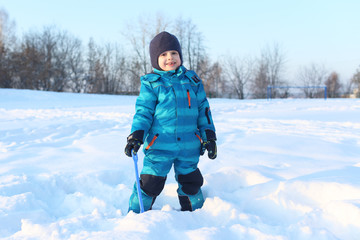 Fototapeta na wymiar Happy little 4 years boy with shovel in winter outdoors