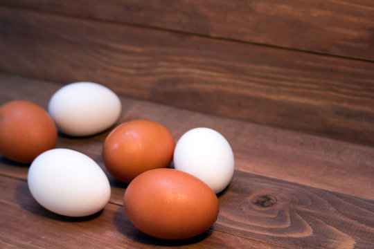 fresh brown and white eggs on a wooden background