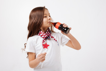 Involved little girl drinking soda pop in the studio