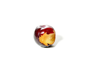 a fresh blue plum with a bite mark, isolated on white background