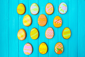 Homemade cookies with icing in the shape of an egg for Easter. Delicious Easter cookies on a blue background. Colored glaze. Cookies for spring mood. Colored eggs on a blue background. Easter bunny