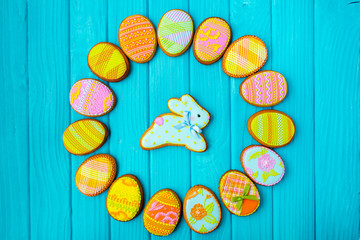 Homemade cookies with icing in the shape of an egg for Easter. Delicious Easter cookies on a blue background. Colored glaze. Cookies for spring mood. Colored eggs on a blue background. Easter bunny