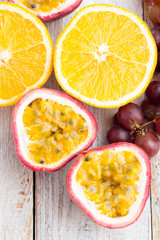 oranges and passion fruit, red grapes close up view from above.