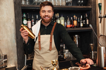 Attractive young bearded man bartender standing in cafe