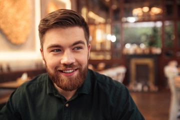 Obraz premium Handsome young bearded man sitting in cafe.
