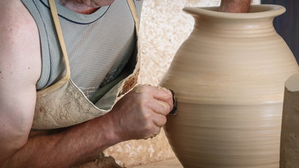 Old craftsman hands working on pottery wheel