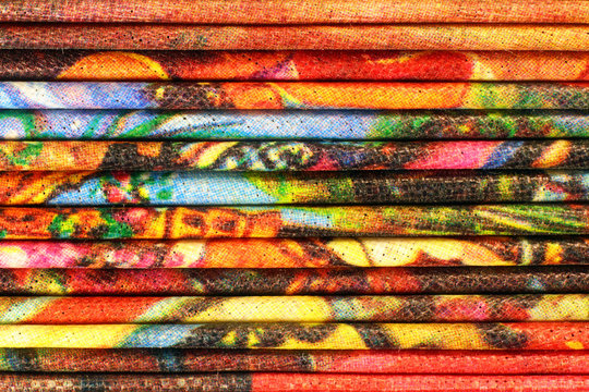 Stack of colorful folded capron cloth. Horizontal layers of reticulated fabric background.