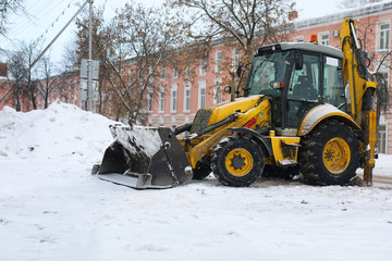 tractor for snow removal is parked on a city street