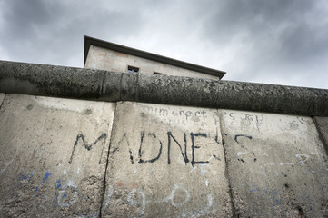 Germany, Berlin, Topography of Terror: Detail of former Berlin wall with old graffiti and dark gloomy clouds in the background. The place is an history museum in the center of the German capital.